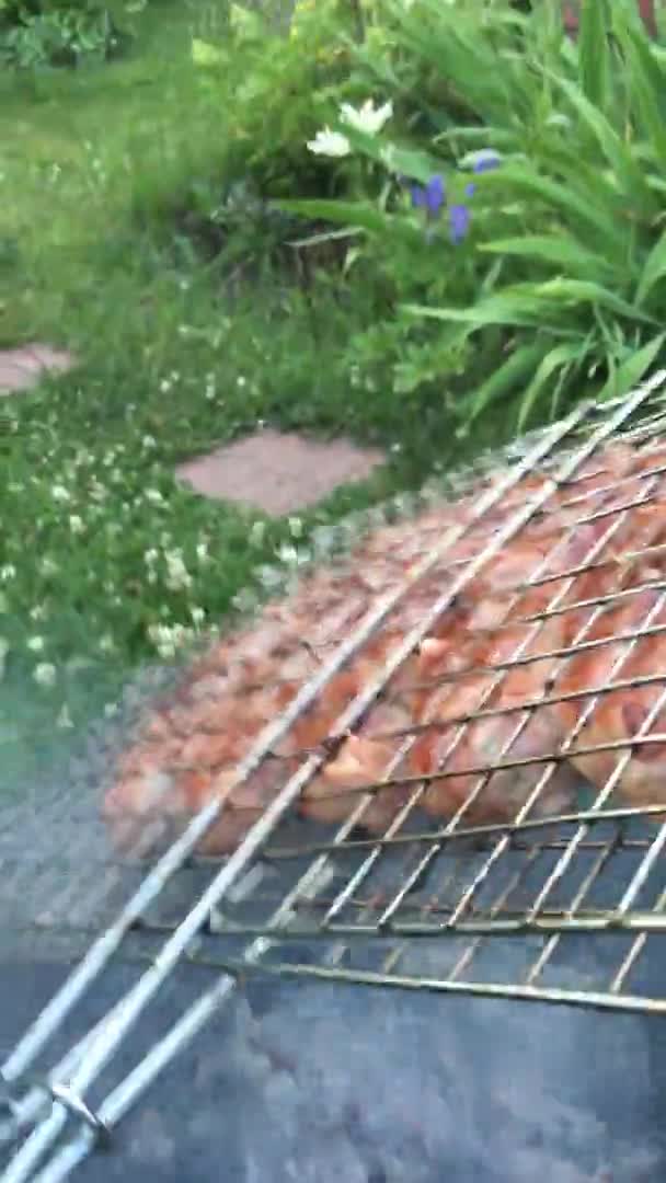 POV Vídeo vertical Volteando Salchichas a la parrilla al aire libre en un jardín trasero. Comida para asar, barbacoa, barbacoa Video de stock