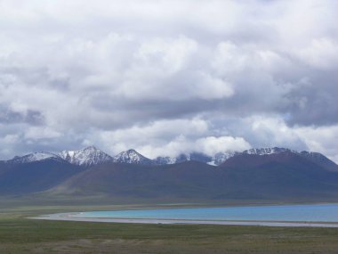 Tibet 'te Namtso Gölü' nün (Nam Gölü) arka planında karlı dağlarla muhteşem bir manzara.