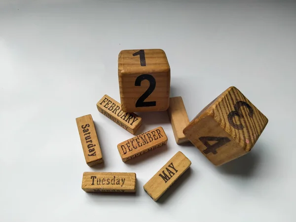 Eski el yapımı tahta küp takvimi, solmuş ve çiziklerle dolu.