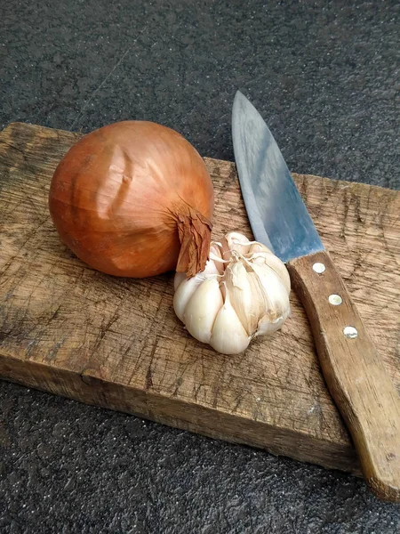 Sarımsak, soğan ve bıçak doğranmaya hazır.