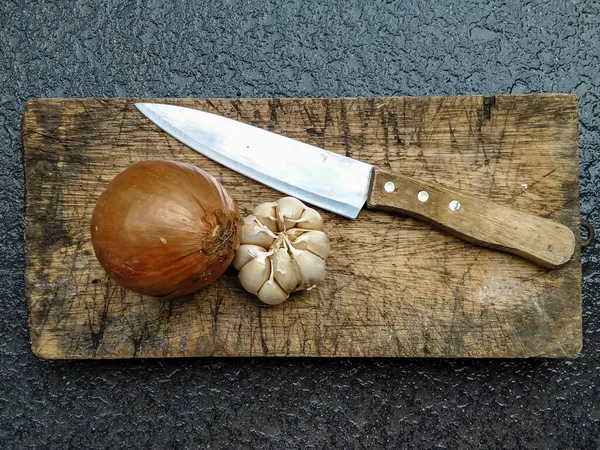 Kesme tahtasında sarımsak ve soğan, üst manzara.