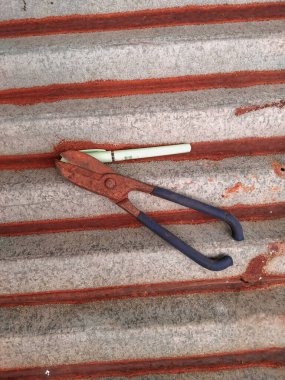 Paslı çinko makas ve eski çinko çatıda bir kalem.