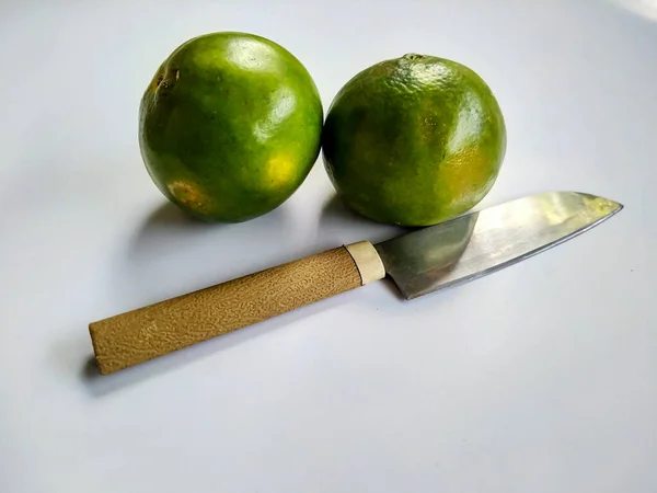 Endonezya mandalina meyvesi ve beyaz üzerine izole edilmiş bir bıçak..
