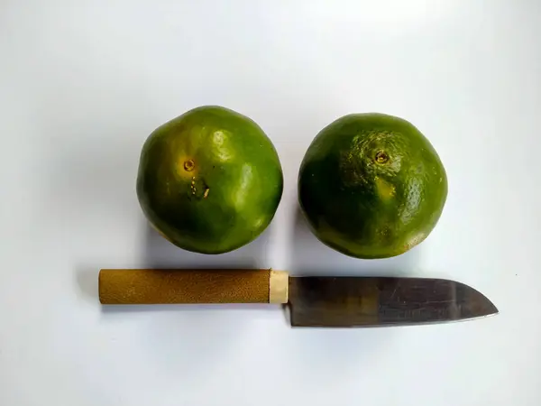 Endonezya mandalina meyvesi ve beyaz üzerine izole edilmiş bir bıçak..