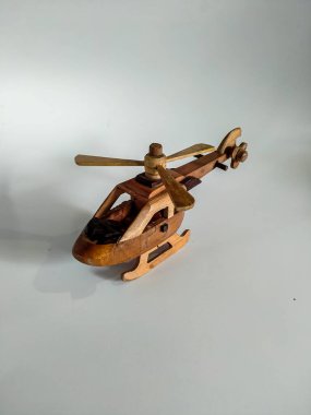 Beyaz arka planda izole edilmiş küçük tahta bir helikopter oyuncağına odaklanın.