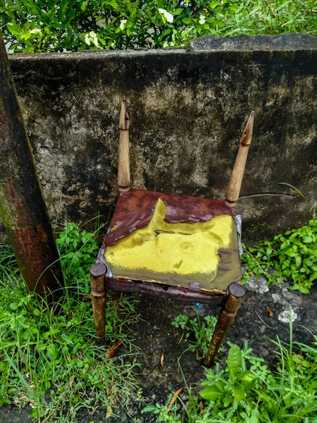 Elektrik direğinin yanında kullanılmamış eski bir tahta sandalye..