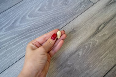 Kadın el ele tutuşma hapları, vitaminlerle el ele, sağlık konsepti