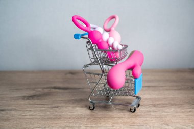 supermarket trolley filled with sex toys vibrator and anal butt plugs. Concept of buying adult toys, e shopping 