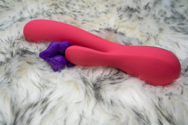 pink vibrator rabbit and lips, concept of woman pleasure, game in bed