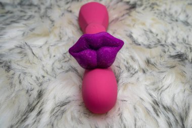 pink vibrator rabbit and lips, concept of woman pleasure, game in bed