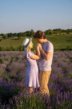 couple in purple matching lilac outfit, hugging, kissing in lavender field. Romantic date concept, perfect relationship. Good picture for cover, calendar, postcard, wallpaper, background, product, website, blog, business, magazine, shop and store