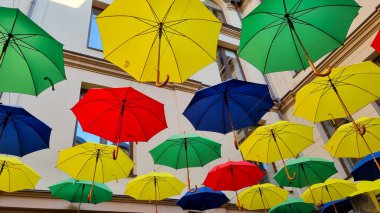 multi color umbrellas as street outdoor decoration, bright blue sky background 