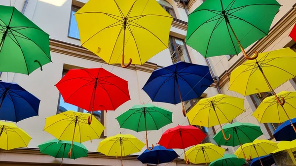 multi color umbrellas as street outdoor decoration, bright blue sky background