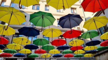 multi color umbrellas as street outdoor decoration, bright blue sky background 