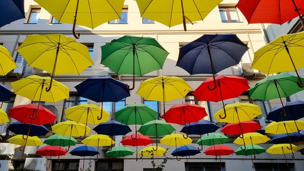 multi color umbrellas as street outdoor decoration, bright blue sky background