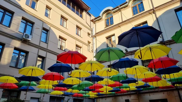 multi color umbrellas as street outdoor decoration, bright blue sky background 