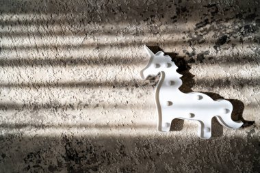 creative light effect, sunbeam stripes on grey background, white unicorn toy  lamp