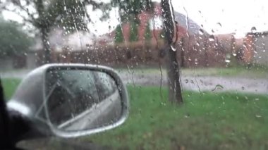 Kötü hava, yağmurlu gün, araba aynasına yağmur damlaları, yolda çekim, sokakta yağmur. 