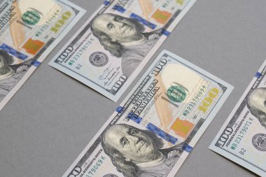 Gri arka planda tek bir ayrı 100 Amerikan doları banknot.