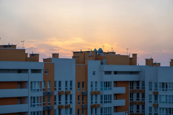 beautiful orange sunset over the city, visible city line of buildings and houses, darkness and sunbeam in sky, early morning, sunrise