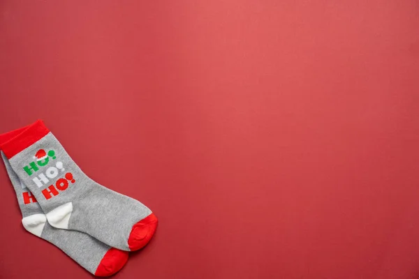 christmas and new year\'s socks on a red background, festive season, holiday clothes ho ho ho, copy space