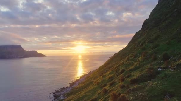 火红的夕阳西下的海面上布满了岩石的火山悬崖 夏季或春季海洋背景 温水金色表面上的小波涛 有来自太阳的亮光 — 图库视频影像