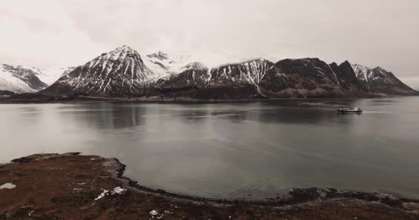 ボートはアイスランドのフィヨルドを旅し 雪に覆われた山々を背景にしています — ストック動画