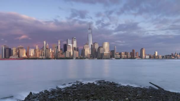 日の出の都市のスカイライン 夜の防波堤からの水の反射 — ストック動画