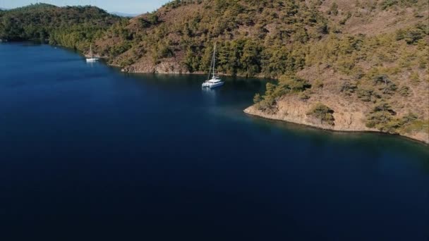 島の森林に覆われた山々の近くを航海船と穏やかな海 エアリコイル — ストック動画