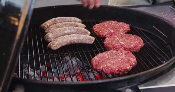 厨师在炭烤架上放香肠 生肉肉饼 — 图库视频影像