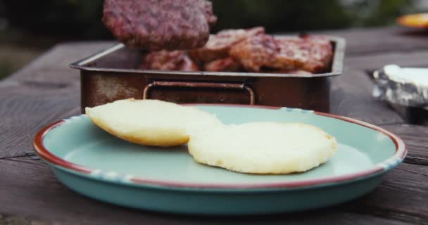 요리사가 맛있는 버거를 자연의 위에서 만들고 있습니다 쇠고기패티 바베큐를 곁들인 — 비디오