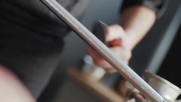 Şef Mutfak Masasının Önünde Bir Bıçağı Keskinleştiriyor Aşçı Çiğ Çeşitli — Stok video