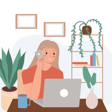 A happy woman is working online, sitting at her laptop talking on the phone. Workplace of a female freelancer working remotely from a home office.Home office concept, a woman working from home