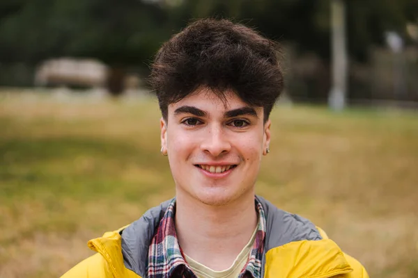 Caucasian happy guy standing in university campus. Portrait of teenage male student looking at camera in a college — Stockfoto