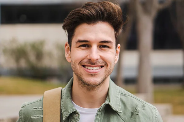 Caucasian happy male in university campus. Portrait of teenage male student standing in a college — Stockfoto