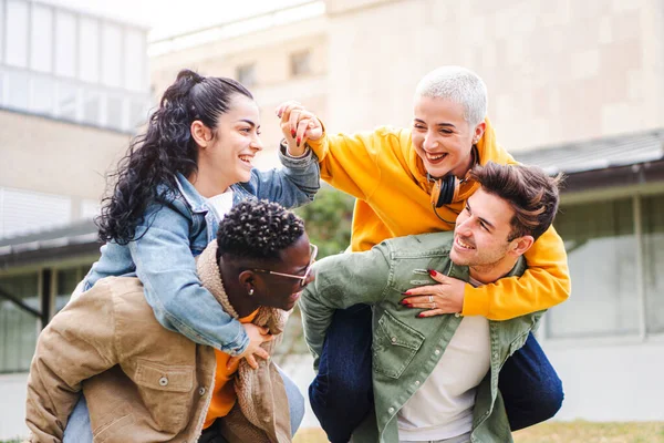 Group Of Happy Young High School Students Giving Piggybacks In Campus, Friends Having Fun Together Outdoors — ストック写真