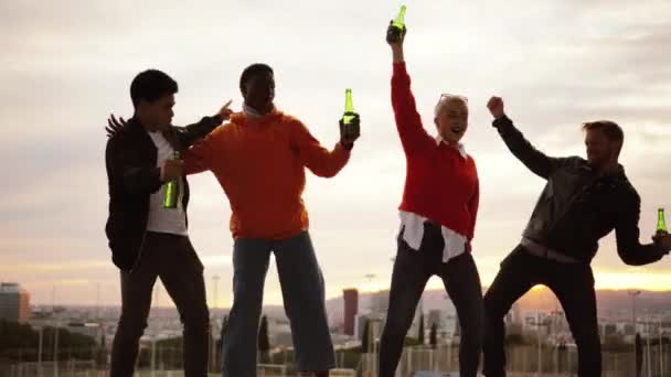 Többnemzetiségű Barátok Táncolnak Isznak Tetőn Alkonyatkor Kiváló Minőségű Felvételek — Stock videók