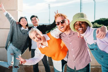 Portrait of cheerful multiracial teen friends posing at camera outdoors, smiling and laughing, enjoying spending time together. high quality photo