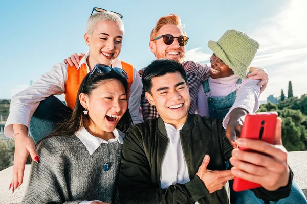Group of friends watching a video in smartphone smiling and having fun together outdoor. high quality photo