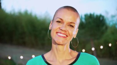Happy short hair woman Looking at Camera. Close Up Portrait of adult woman laughing and smiling outdoors at sunrise. High quality 4k footage