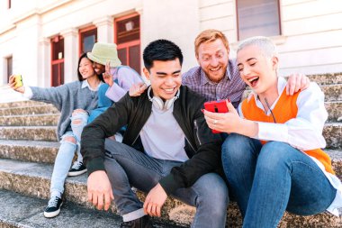 Group of young multiethnic friends watching media with a smartphone together having fun and laughing. high quality photo