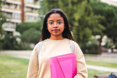 Serious hispanic teen standing outdoors at university capus looking at camera with his googles. Portrait of pretty school girl. High quality 4k footage
