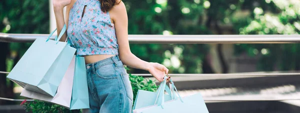 買い物袋を持っている買い物客アジアの女性 彼女の顔は笑顔で青いシャツを着ている お客様は夏の販売都市ライフスタイルコンセプトをお楽しみください バナーサイズの背景 — ストック写真