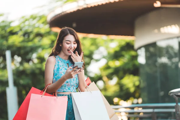 美しい笑顔若いアジアの女性は スマートフォンの購入を保持し オンラインで支払う 休日の販売の季節の概念でショッピング 街の女の子のライフスタイル幸せな屋外活動 — ストック写真