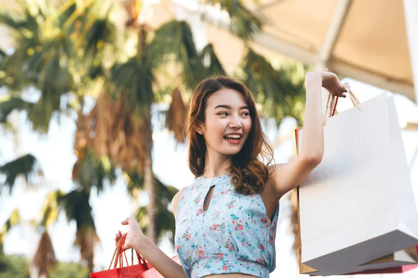 休日の独身生活をしている ショッピングバッグで育った幸せな若い大人のアジアの女性の手 コピースペースの背景 — ストック写真