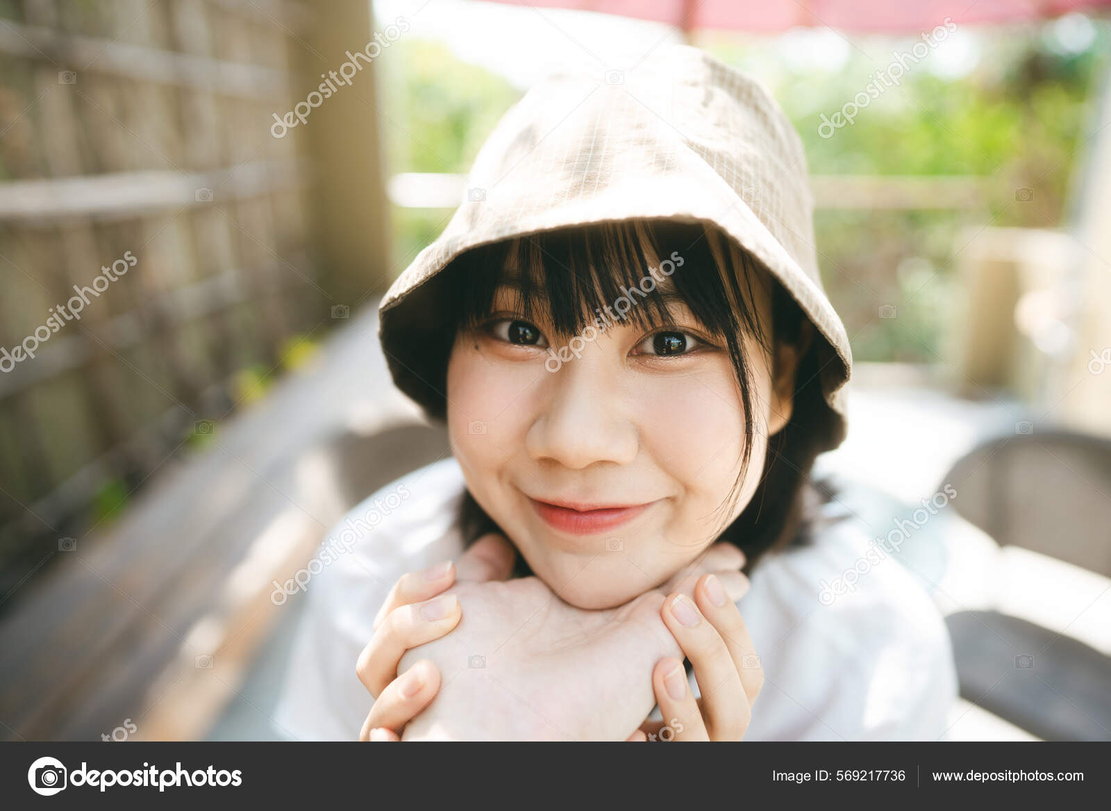タイ人　ハメ撮り 美しい彼女のハメ撮りビューポートレート 幸せな若い大人のアジアの女性のカメラを探して 日中は屋外でカップルの手で顔 バケツ帽子と白いシャツを着て —  ストック写真 © dodotone #569217736