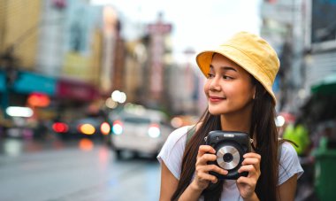 Sırt çantalı, beyaz tişörtlü, Asyalı yalnız gezgin kadın. Yaowarat 'ın yanında hazır kamera bulundurun. Çin Mahallesi sokak yemekleri arka planında fotokopi alanı var. Bangkok Şehri, Tayland