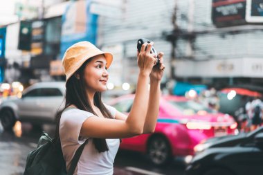 Genç Asyalı yalnız gezgin kadın rahat bir şekilde sırt çantasıyla rahatla. Yaowarat 'ta yürürken anlık kamerayla fotoğraf çek. Çin Mahallesi sokak yemekleri. Bangkok Şehri, Tayland