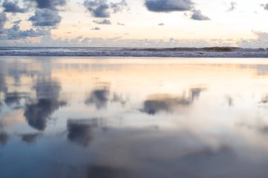 Gün batımında deniz dalgası ve kumsal kumları. Kimse sakin ve sakin olamaz.