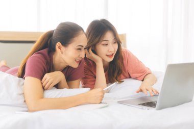 İlişki konseptiyle birlikte yaşayan iki yetişkin kadın. Doğru kişiye odaklan. Güneydoğu Asyalıların dostluğu yatak odasında uzanıyor ve sabahları iş hakkında konuşuyor..
